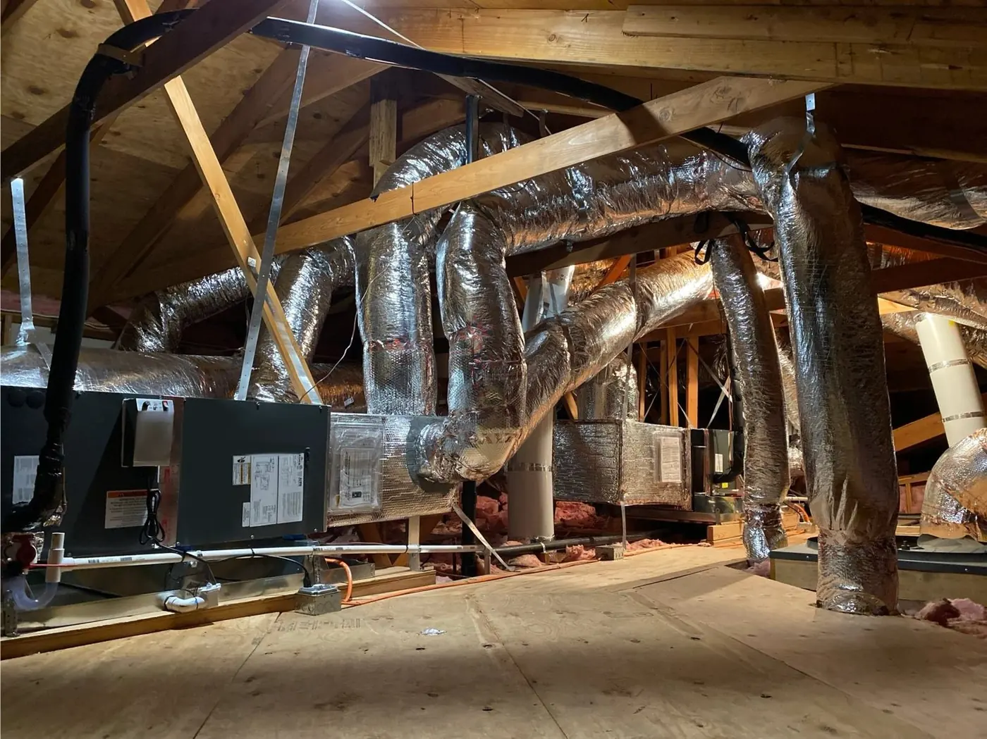 Newly installed attic air handler with insulated flexible duct runs to a supply plenum