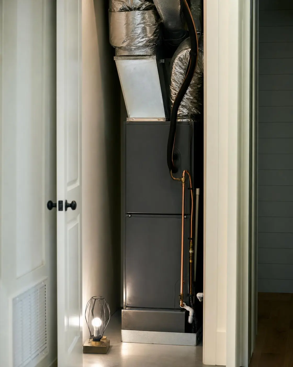 Residential mechanical closet with a vertical air handler, plenum, and insulated duct runs